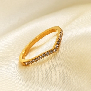 Minimalist gold V-shaped stainless steel ring with micro-pave crystals on satin background