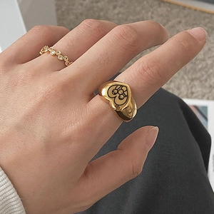 Detailed view of stacked gold heart ring with character engraving and a diamond band