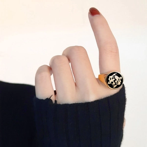 Macro detail of signet ring featuring golden koi fish engraving on black circular face