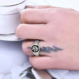 Close-up of a silver signet ring with black and white koi fish design on a round face