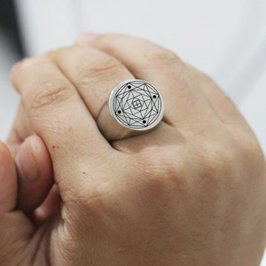Détail d'une bague chevalière en acier argenté avec gravure géométrique sur une main
