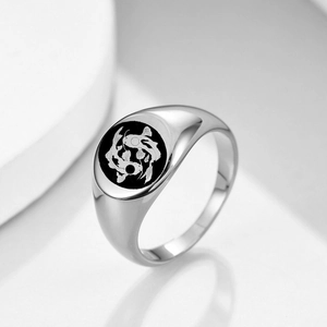 Detail of a round stainless steel signet ring with engraved black and white koi fish motif