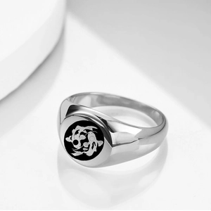 Macro view of silver stainless steel signet ring with engraved black Pisces koi motif