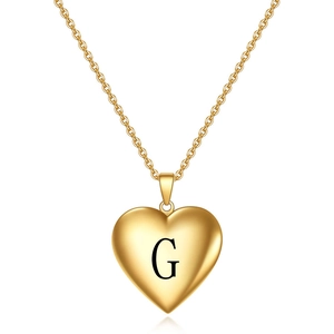Détail d'un collier avec pendentif cœur doré et gravure minimaliste de la lettre G au centre