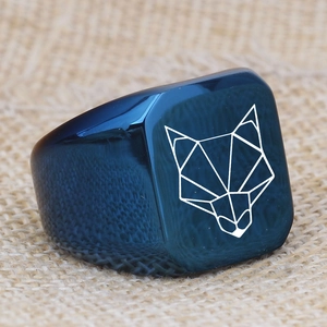 Dettaglio di un anello a sigillo quadrato blu scuro con logo geometrico a testa di volpe