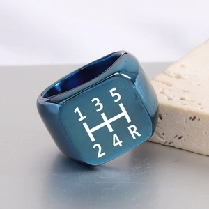 Dettaglio macro anello quadrato blu in acciaio con motivo marce inciso al laser