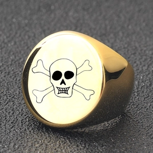 Macro shot of gold stainless steel signet ring featuring laser engraved skull and crossbones