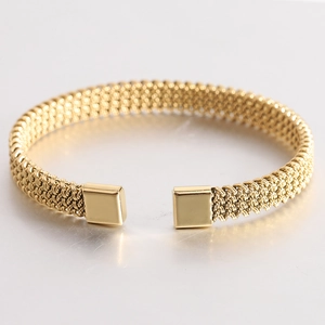 Detail of golden woven mesh texture on stainless steel open cuff bracelet with square ends