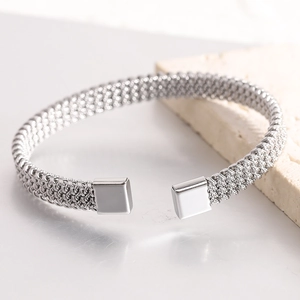 Detailed macro view of silver braided stainless steel cuff bracelet with square end caps