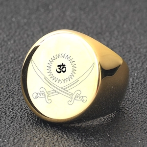 Macro detail of golden stainless steel signet ring featuring laser engraved Om and sun motifs