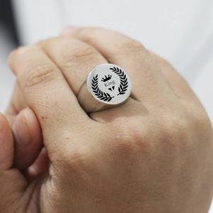 Macro view of silver stainless steel signet ring featuring king crown and laurel design