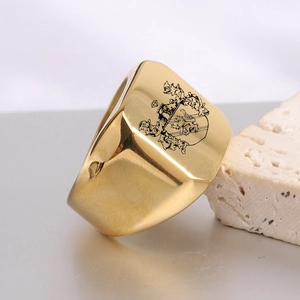 Detailed macro view of gold square signet ring featuring a black vintage griffin crest