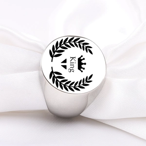 Macro view of polished silver steel signet ring with laurel wreath and King engraving