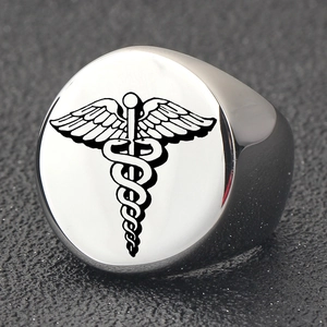 Macro detail of polished stainless steel signet ring with engraved black caduceus symbol