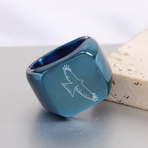 Macro-opname van de donkerblauwe vierkante ring met lasergegraveerde arend en metalen finish
