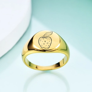 Detail of 18K gold-plated signet ring featuring a polished apple and star motif