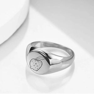 Macro shot of 12mm silver stainless steel ring featuring engraved apple design