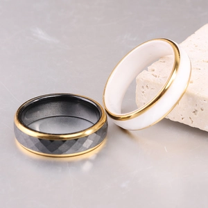 Detalle de anillos de acero inoxidable dorado de 6mm con facetas negras e inserto cerámico