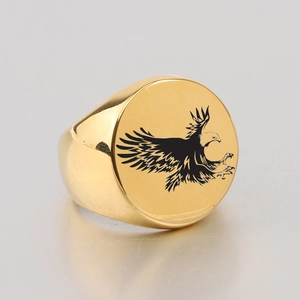 Close-up of golden stainless steel signet ring with black eagle laser engraving
