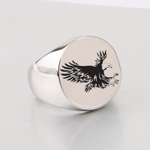 Macro shot of silver stainless steel signet ring with black eagle laser engraving