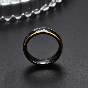 Vista macro de anillo de 6mm en cerámica negra facetada con bordes de acero dorado
