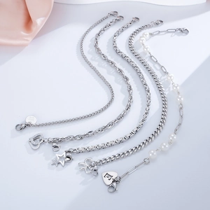 Close-up of stainless steel charms including heart letter E and stars with pearls