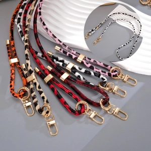 Detail of leopard and zebra print crossbody straps with premium gold metal clasps