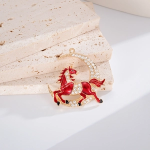 Détail d'un cheval en émail rouge et lune en cristal sur texture pierre naturelle