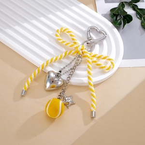 Détail d'un bijou de sac nœud tennis avec mousqueton cœur et pendentif étoile