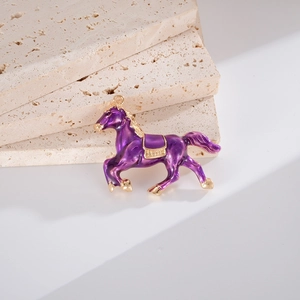 Vue détaillée d'un pendentif cheval en émail violet avec accents dorés sur fond de pierre