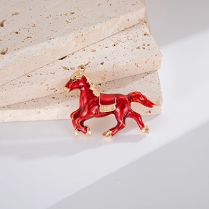 Vue macro d'un pendentif cheval en émail rouge avec détails de selle dorés texturés
