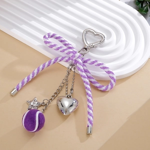 Détail du porte-clés nœud en nylon avec balle de tennis violette et cœur argenté