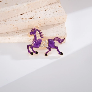 Gros plan du pendentif cheval en émail violet avec bordure dorée et cristaux brillants