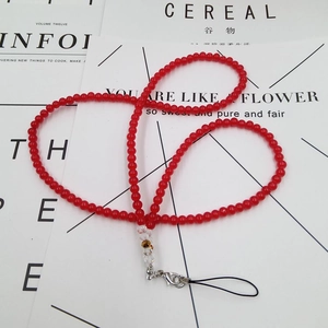 Detail of red beaded phone lanyard with metal lobster clasp and decorative beads