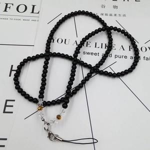 Detail view of long beaded crystal phone lanyard with black beads and silver metal clasp