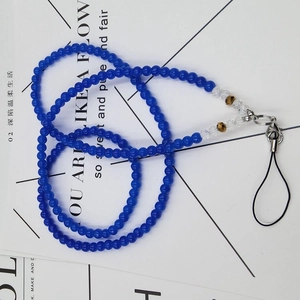 Detail view of a deep blue beaded phone lanyard with golden charms and silver lobster clasp