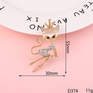 Detailed view of a golden fox brooch with crown, beige cat eye stone and white zircons