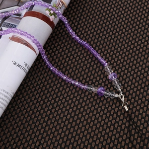 Close-up of purple faceted bead phone strap with silver lobster clasp and black loop cord