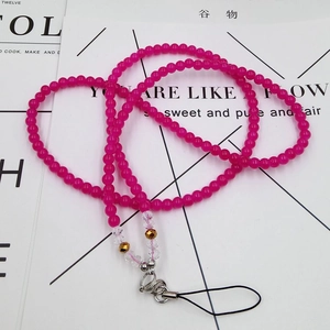 Macro detail of rose red beaded phone lanyard with golden accents and metal lobster clasp