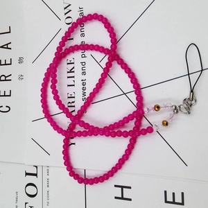 Detail of pink beaded phone lanyard with gold accents and lobster clasp for accessories