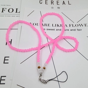 Detail of pink matte beaded phone lanyard with a silver lobster clasp on a stylish card