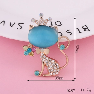 Macro detail of a cat brooch with blue opal head and crown on pink background