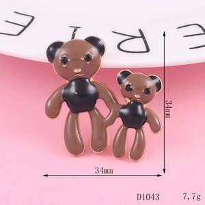 Detailed view of a hand-in-hand teddy bear brooch in brown enamel with black rhinestones