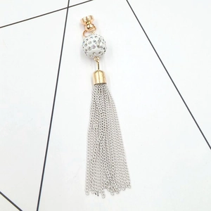 Close-up of golden rhinestone ball charm with delicate silver chain fringe tassels