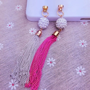 Detailed view of long tassel earrings with sparkling rhinestones in grey and rose red