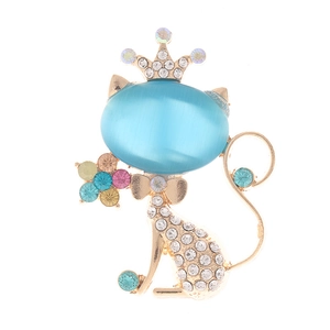 Detailed close-up of golden cat brooch with blue cat eye stone and crown rhinestones