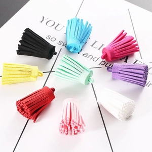 Macro shot of 9 colorful 3cm faux suede tassels with ring loops for DIY craft projects