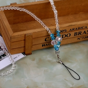 Detail of beaded mobile strap with clear and blue faceted beads and metal lobster clasp