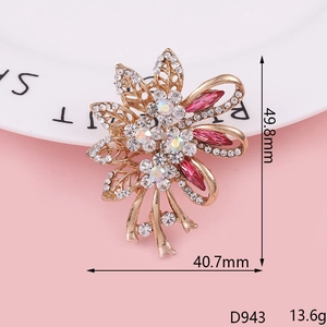 Détail macro d'une broche fleur dorée avec strass roses et cristaux blancs sur l'assiette