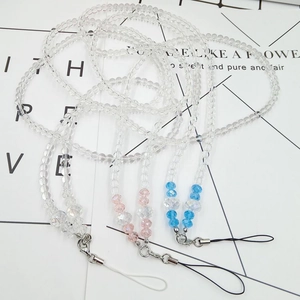 Close-up of transparent beaded phone straps with crystal facets and metal lobster clasps